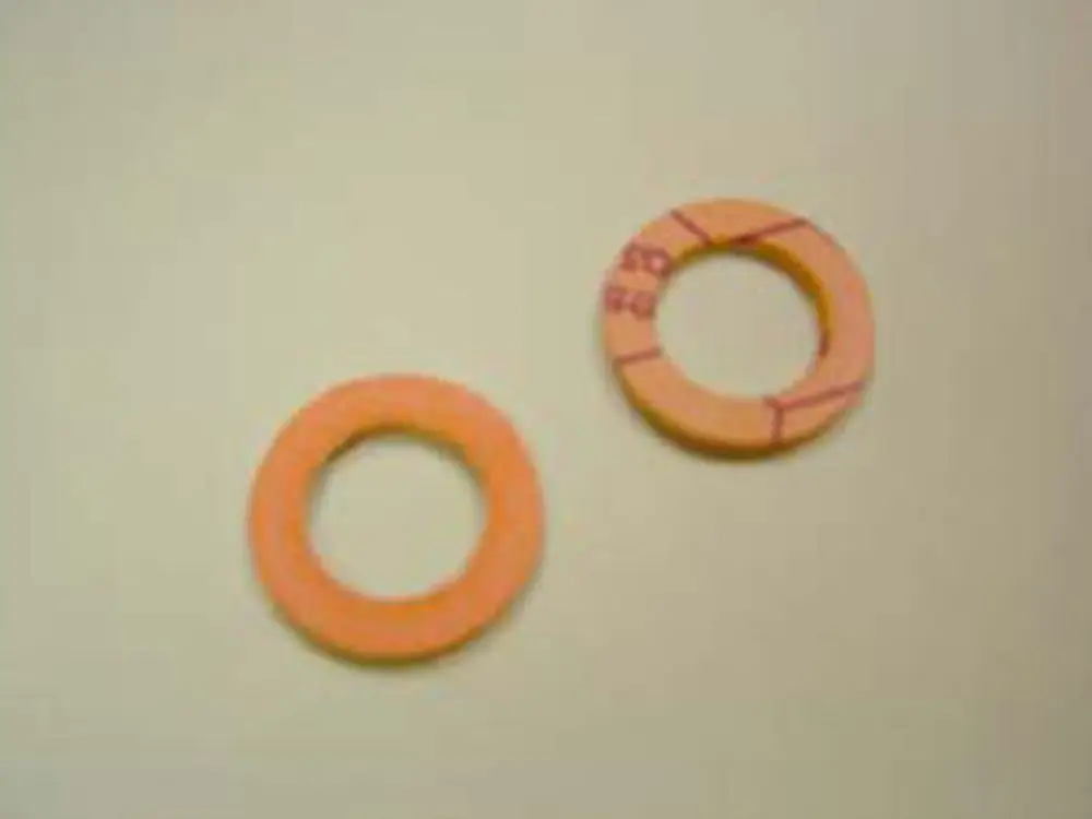 Zwei runde Dichtungen aus einem orangefarbenen Material, eine mit markierter Innenfläche, auf neutralem Hintergrund, möglicherweise von der Marke Remeha.